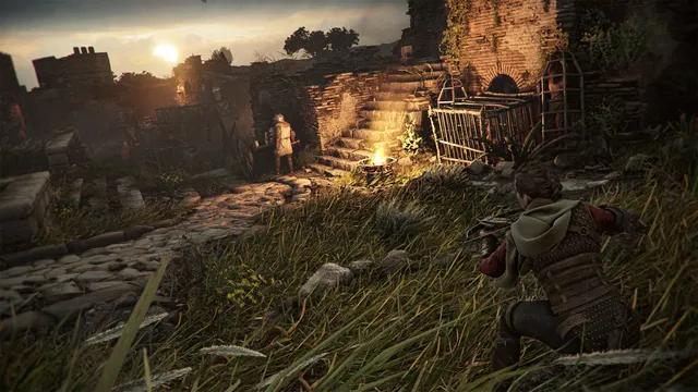 Amicia crouching in long grass with her crossbow, watching a guard by a fire in old ruins at sunset