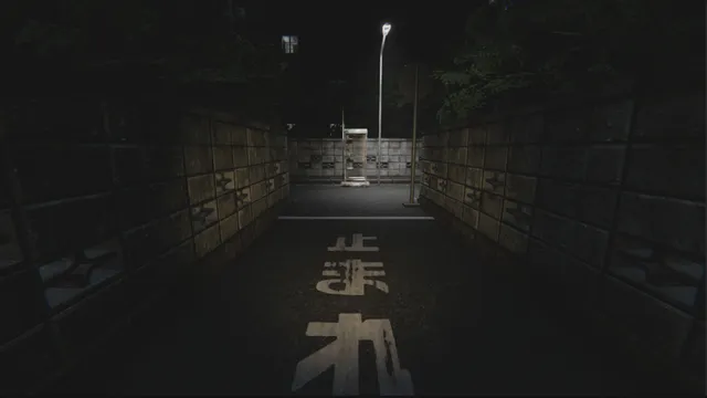 A dark lane at night ending at a phone box, with Japanese road markings on the asphalt