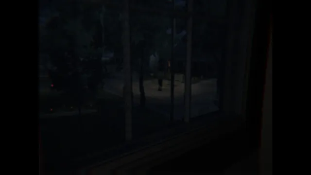 Alone. Again. screenshot: looking out of a dark window at a tree-lined street where a man stands still in the road