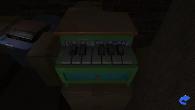 A child's toy piano with lettered keys on a table in the dim attic