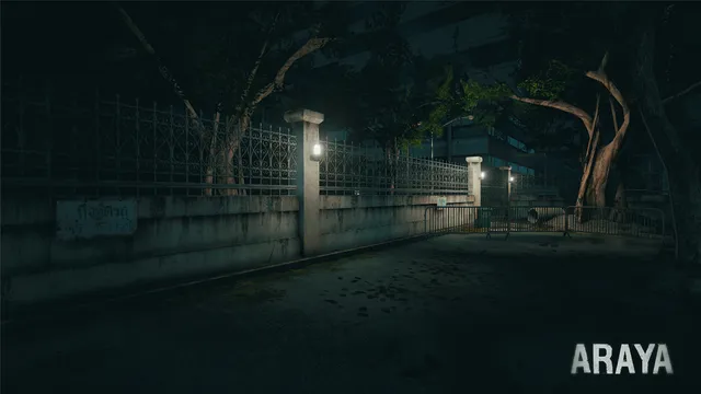 ARAYA: the gated entrance of the hospital at night under large old trees, with a sign in Thai