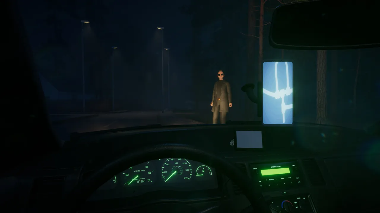 Backseat screenshot: from the taxi's driver seat at night, a man in sunglasses and a long coat waits by the road among dark trees