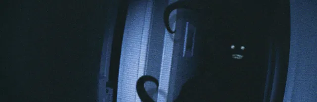 CAPTURED key art: a dark figure with small white eyes and a grin peers around a doorway, with tentacles curling in the grainy camcorder light