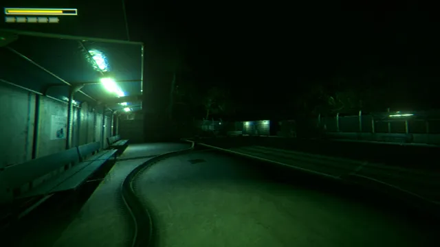 A covered walkway beside the school grounds at night under green fluorescent light