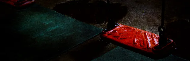 Missing Children key art: an empty red playground swing hanging over dark wet ground at night