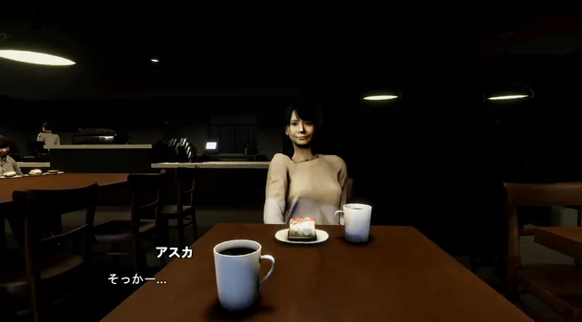 Asuka sits across a table with coffee and cake in a dim cafe