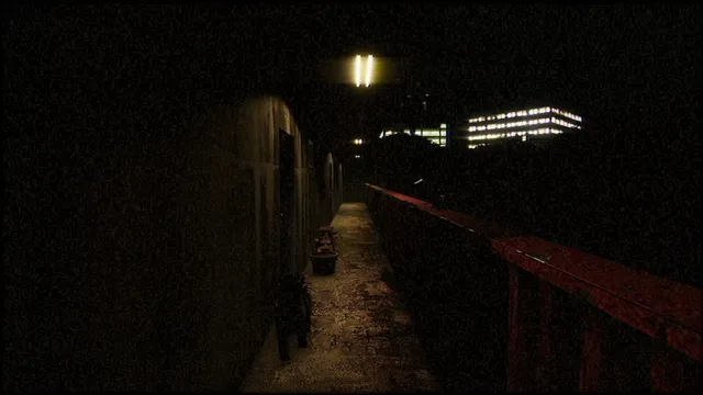 A dim corridor along the apartment block with a red railing and a single light overhead
