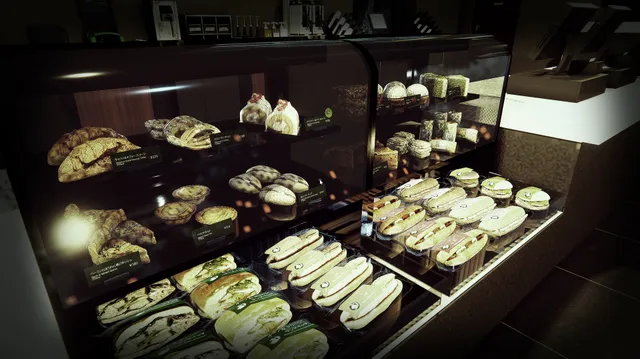 A lit display case of pastries and sandwiches behind the cafe counter
