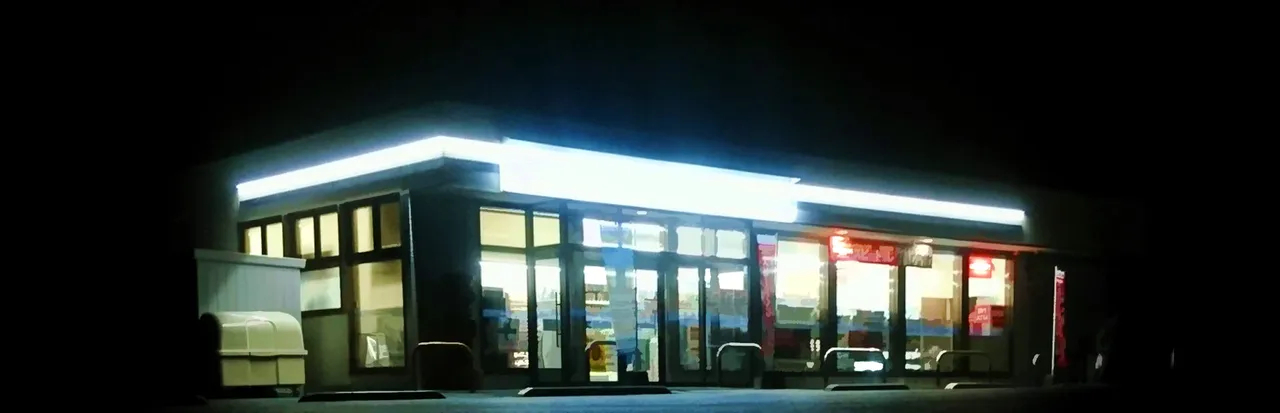 The Convenience Store key art: a Japanese convenience store glowing under its white sign on a dark night street