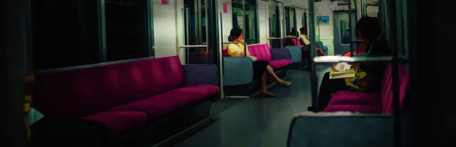 The Ghost Train key art: the inside of a Japanese commuter train with pink seats and a few passengers in dim light