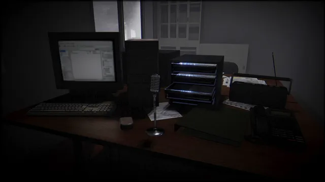 A desk in the dark station office with an old computer, a small microphone, a phone and stacked trays