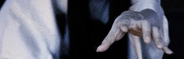 Yuki Onna key art: the pale hand of a woman in a white kimono reaching out in the dark