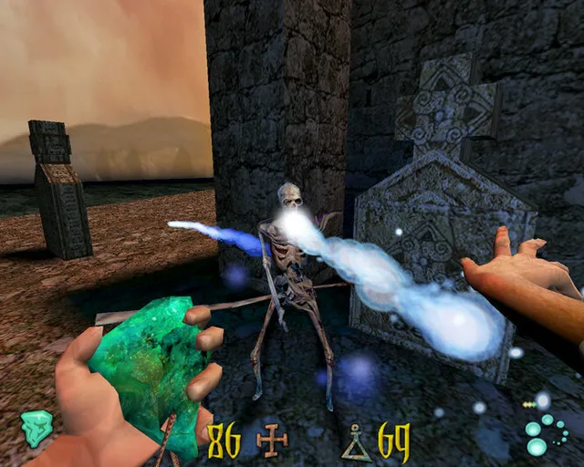 Clive Barker's Undying screenshot: a skeleton among gravestones is hit by a blue spell while the player's other hand holds a green stone