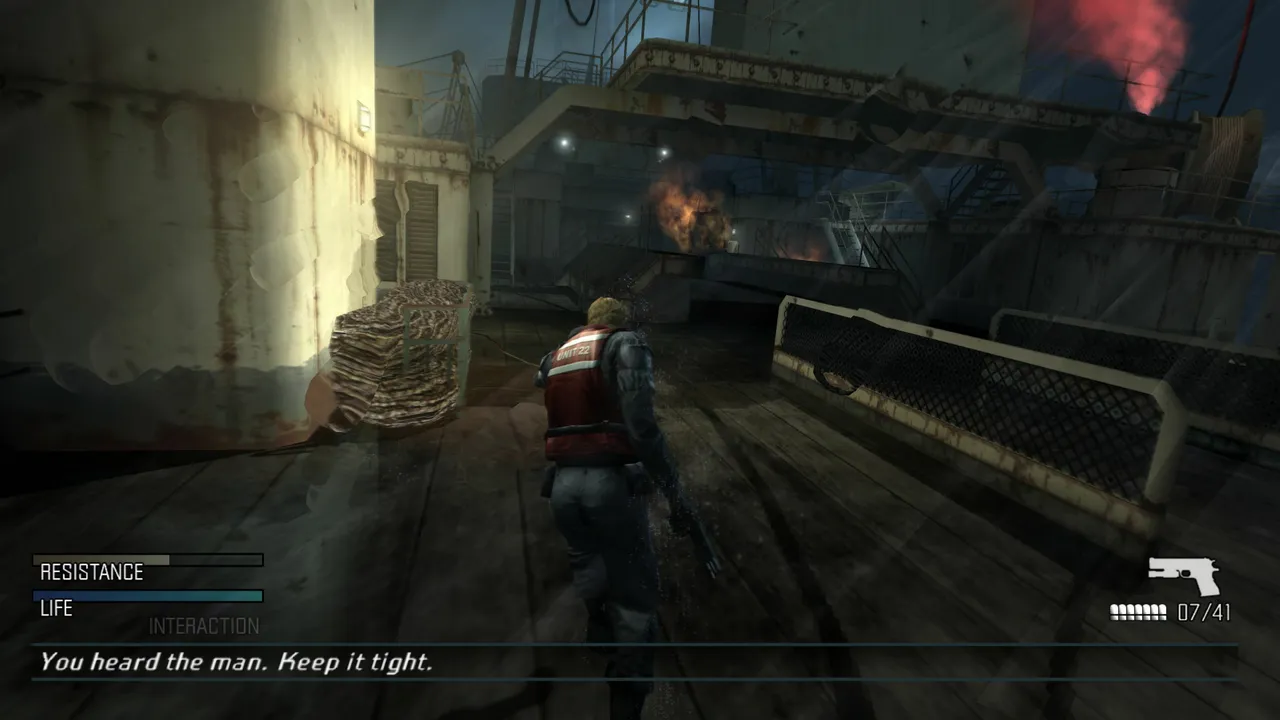 Cold Fear screenshot: Tom Hansen in a Coast Guard vest walks the wet deck of the whaling ship at night, fires burning on the superstructure ahead