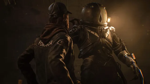 Cronos: The New Dawn screenshot: the Traveler in his riveted helmet stands beside a figure in a hooded jacket in dim amber light
