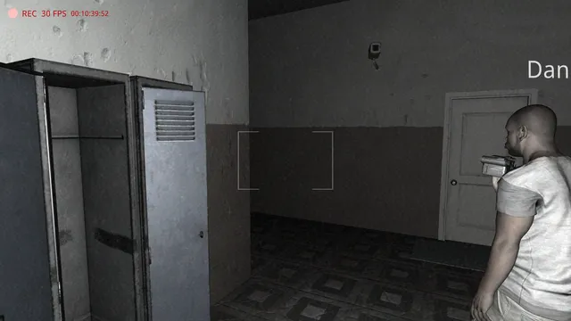 Cursed Apartment screenshot: a player with a camcorder beside open lockers in a dim corridor, seen through a recording frame