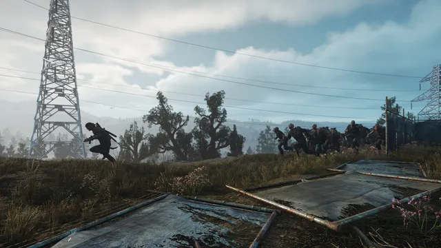 Days Gone screenshot: Deacon runs across a field under power pylons as a horde of Freakers pours after him