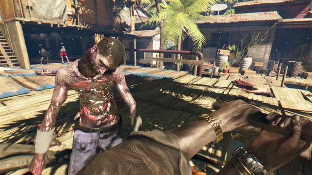 Dead Island: Riptide screenshot: a bloodied zombie closes in on the player in a sunlit stilt village