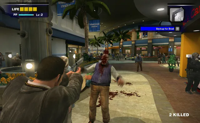 Dead Rising screenshot: Frank fires a handgun at close range into a bloodied zombie in a mall plaza with palm trees