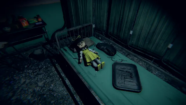 A doll in a yellow dress lies on a narrow bed beside a tray in a dim, teal-lit room