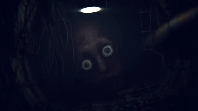 A huge face with staring white eyes looming out of a dark tunnel under a lamp