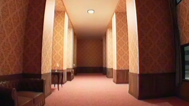 A long hotel corridor with patterned wallpaper, a leather sofa and red carpet