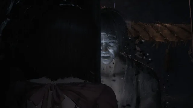 Fatal Frame II: Crimson Butterfly Remake screenshot: a pale, open-mouthed ghost of a man appears beside a rope as Mio looks on