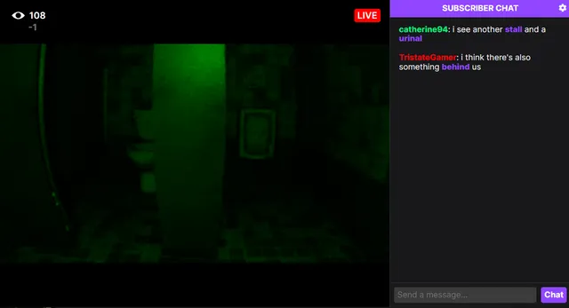 FeedVid Live screenshot: a very dark green view of bathroom stalls as the chat notices something behind the camera