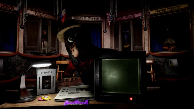 Five Nights at Chuck E. Cheese's: Rebooted screenshot: a hatted animatronic leans over the nightwatchman's desk with its lamp, Stage Call box and small monitor, under the stage windows