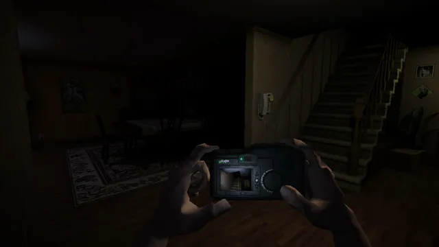 Hands holding a digital camera in a dark hallway at the foot of the stairs