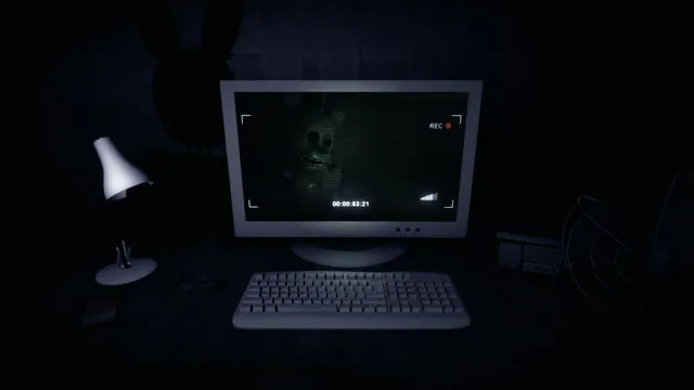 An old security office at night: a desk lamp, keyboard and computer monitor showing a camera feed of a withered rabbit animatronic