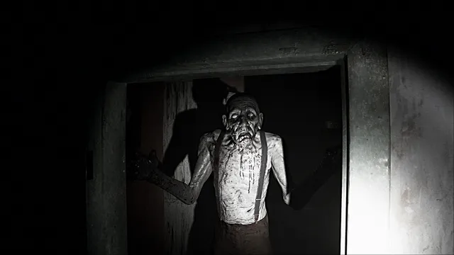 A gaunt, bloodied old man in braces stands in a doorway in the flashlight beam