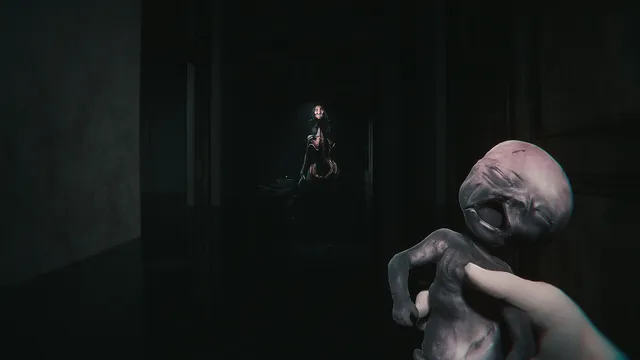 A first-person hand holds a grey, fetus-like doll while a pale figure waits in a dark doorway behind it