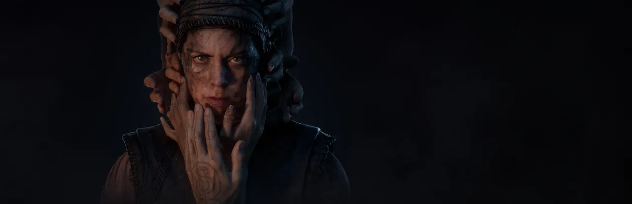 Hellblade II: Senua's Saga key art: Senua's grim, dirt-streaked face surrounded by many hands reaching from the darkness to touch her head