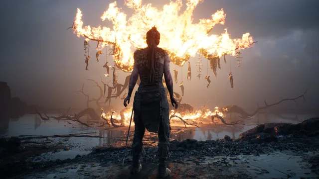 Hellblade: Senua's Sacrifice screenshot: Senua stands before a burning tree hung with bodies on a dark, flooded shore