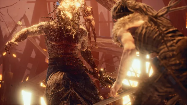 Hellblade: Senua's Sacrifice screenshot: Senua faces a huge warrior with a burning head of thorns in a fiery wooden hall