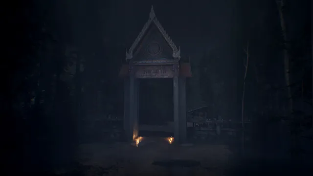 An ornate Thai temple gate standing alone in a dark forest, two candles at its base