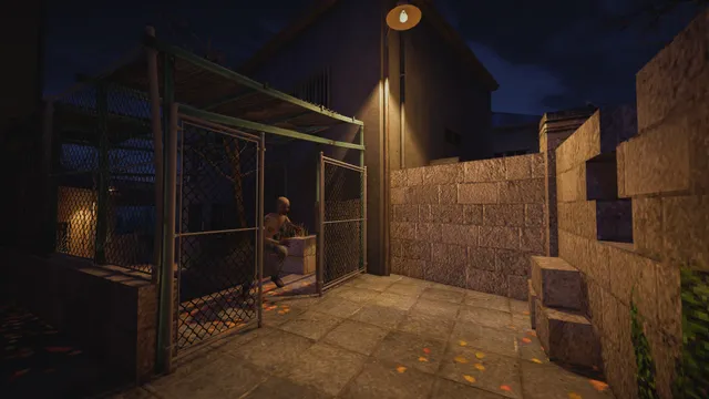 A figure crouches inside a chain-link cage in a lamplit courtyard at night