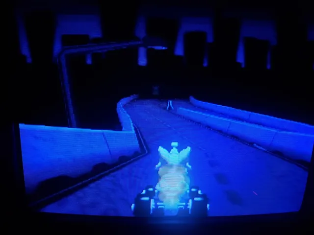 Kitty Kart 64 on an old television: the kart on a glowing blue track in a dark, empty arena