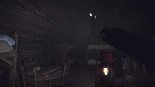 Holding a lantern up in a dark log cabin with bunk beds and a card table