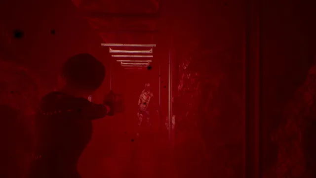 A corridor washed in red light as a pale creature lurches toward the heroine