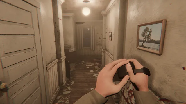 A dim hallway of Martha's House with blood on the walls, seen past the player's hands on a video camera