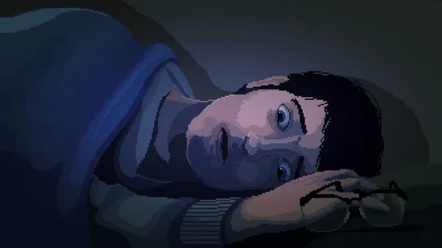 Phil lying awake with his head on the bed, glasses beside him, in dim blue light