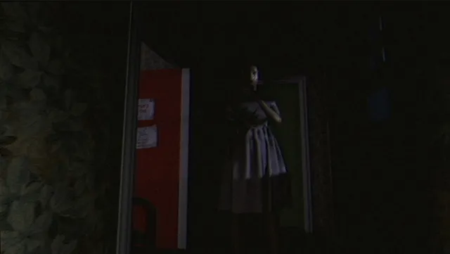 A figure in a dress standing in a dark doorway of the house, seen through a VHS filter