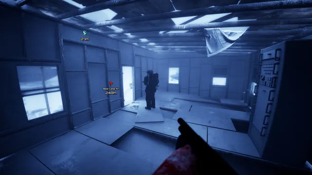 Inside a frozen research cabin, a player with a backpack stands among broken floor panels while another holds a shotgun