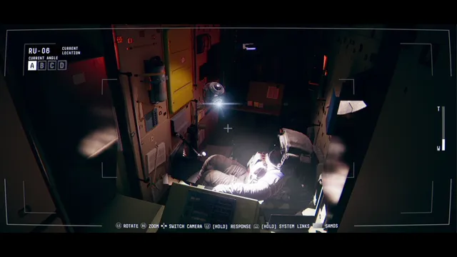 A dim, cluttered module where a figure in a spacesuit sits under a single light