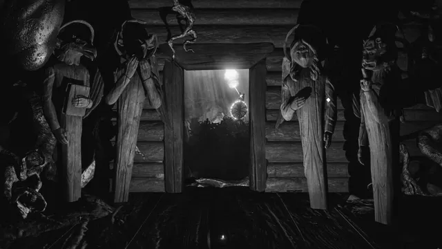 Tall carved wooden idols on either side of a doorway in a log hut, with light beyond