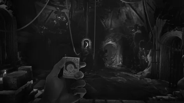 A hand holding a matchbox in a dark carved wooden temple with arched doorways