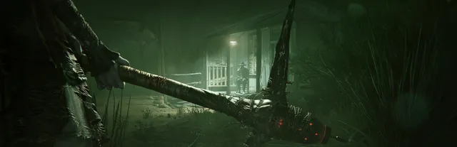 Outlast 2 art: a figure in the dark grass holds a long pickaxe, a lit shack and another figure in a green haze behind