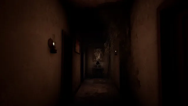 A long dark hallway lit by small wall lamps, with a picture at the far end